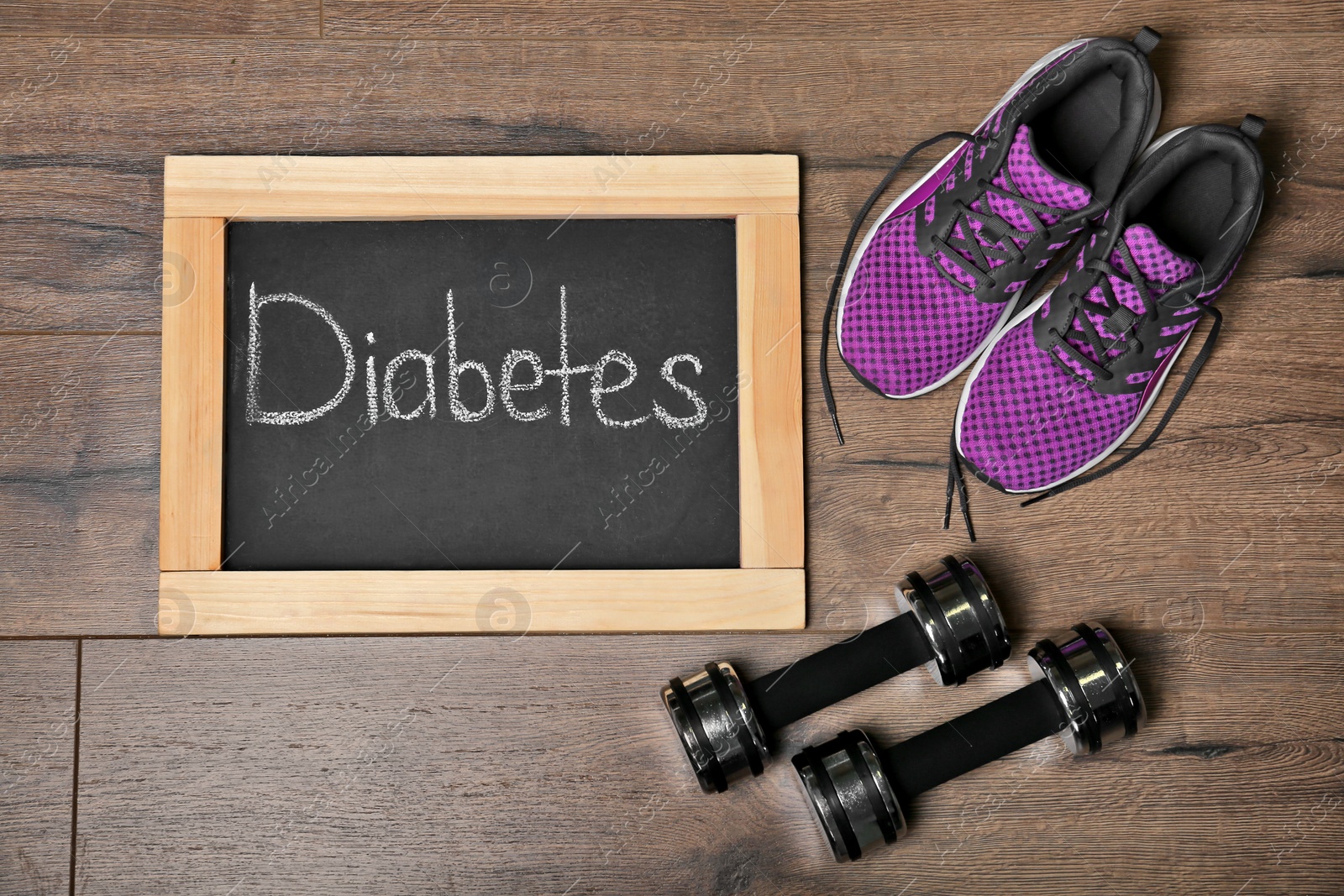 Photo of Flat lay composition with word DIABETES, sneakers and dumbbells on wooden background