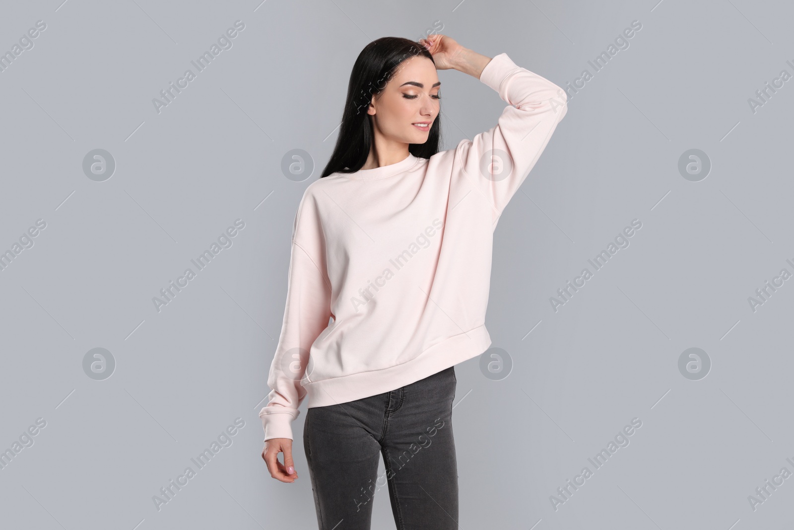 Photo of Portrait of young woman in sweater on grey background. Mock up for design