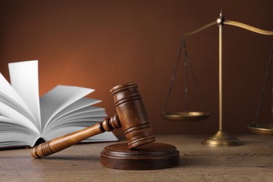 Wooden gavel, scales and book on table. Law concept