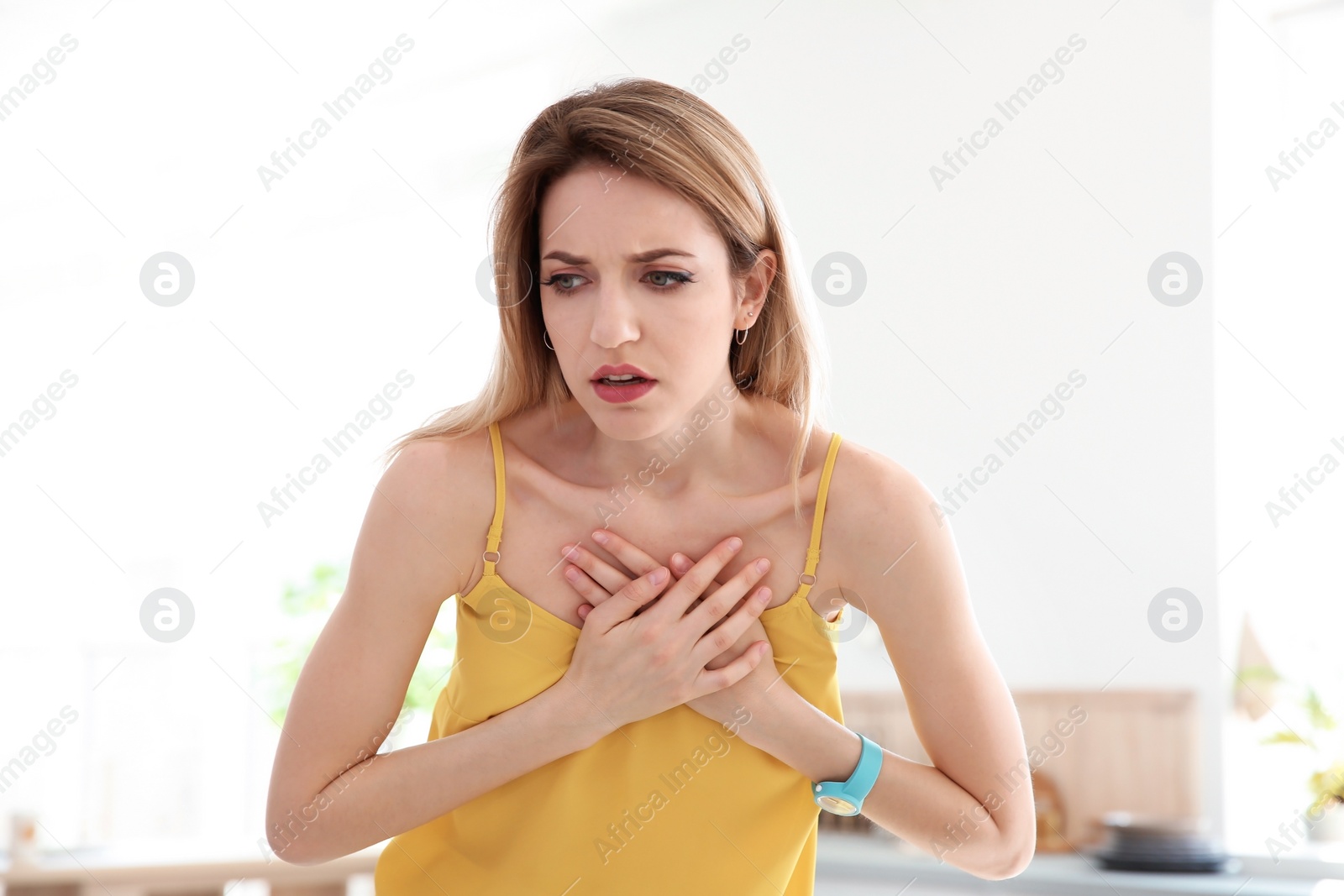 Photo of Young woman having heart attack indoors