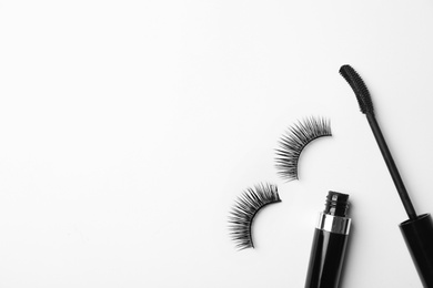 Photo of Flat lay composition of black mascara and false eyelashes on white background