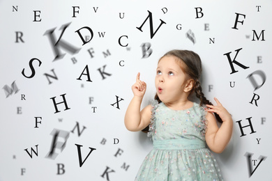Cute little girl and letters on light grey background. Speech therapy concept