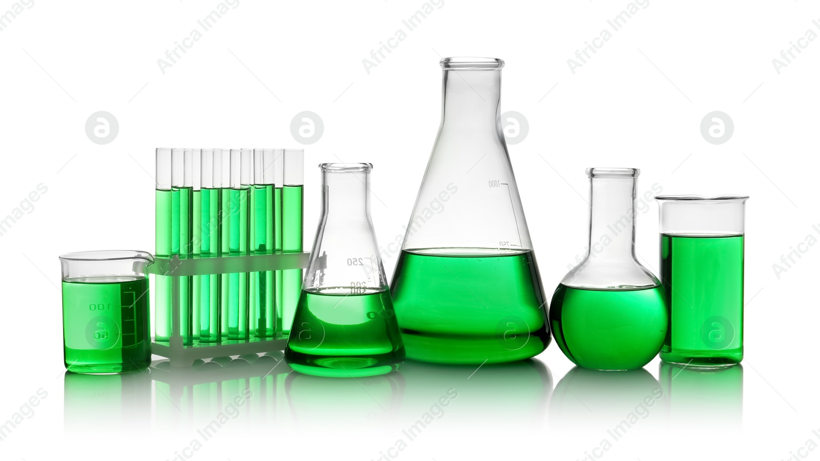 Photo of Laboratory glassware with green liquid on white background