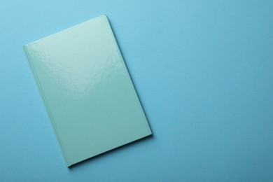 Photo of New turquoise planner on light blue background, top view. Space for text