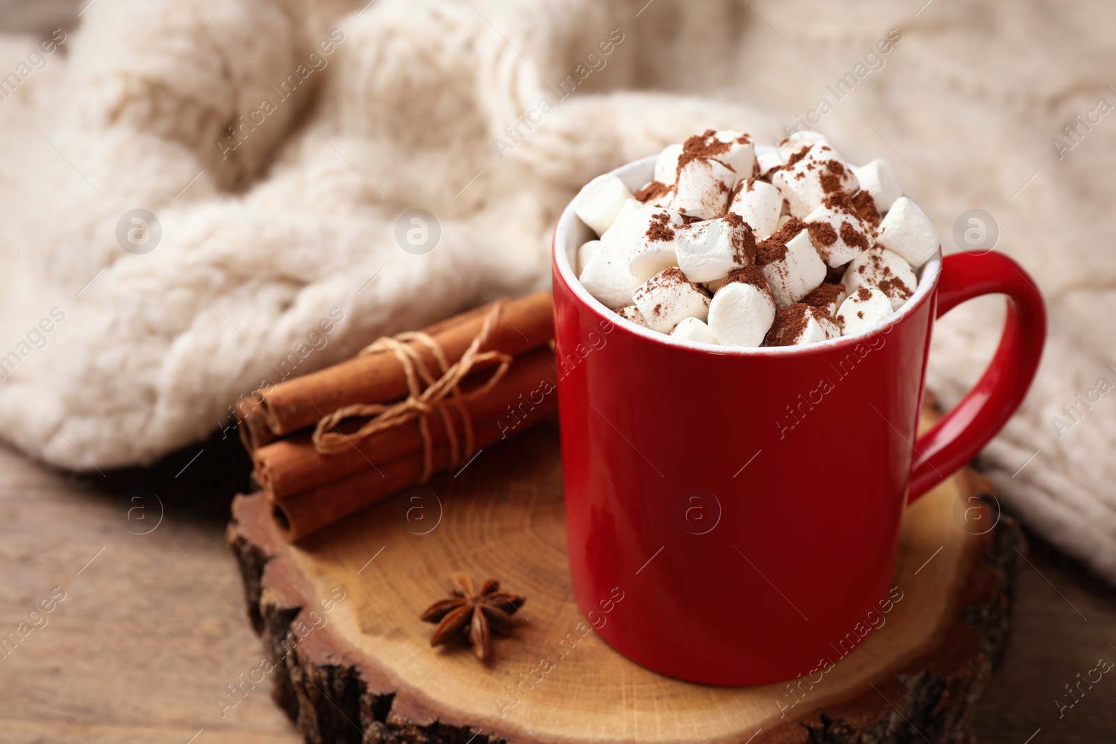 Photo of Composition of tasty cocoa with marshmallows in cup on wooden table. Space for text