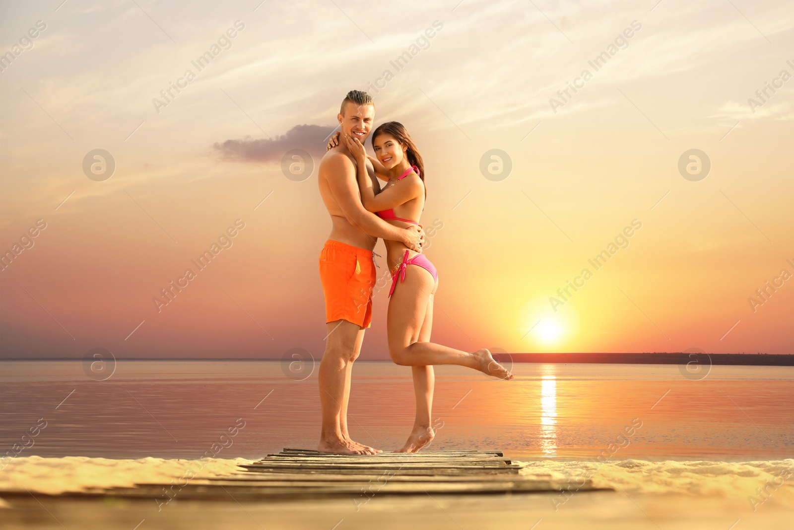 Photo of Young woman in bikini spending time with her boyfriend on beach. Lovely couple