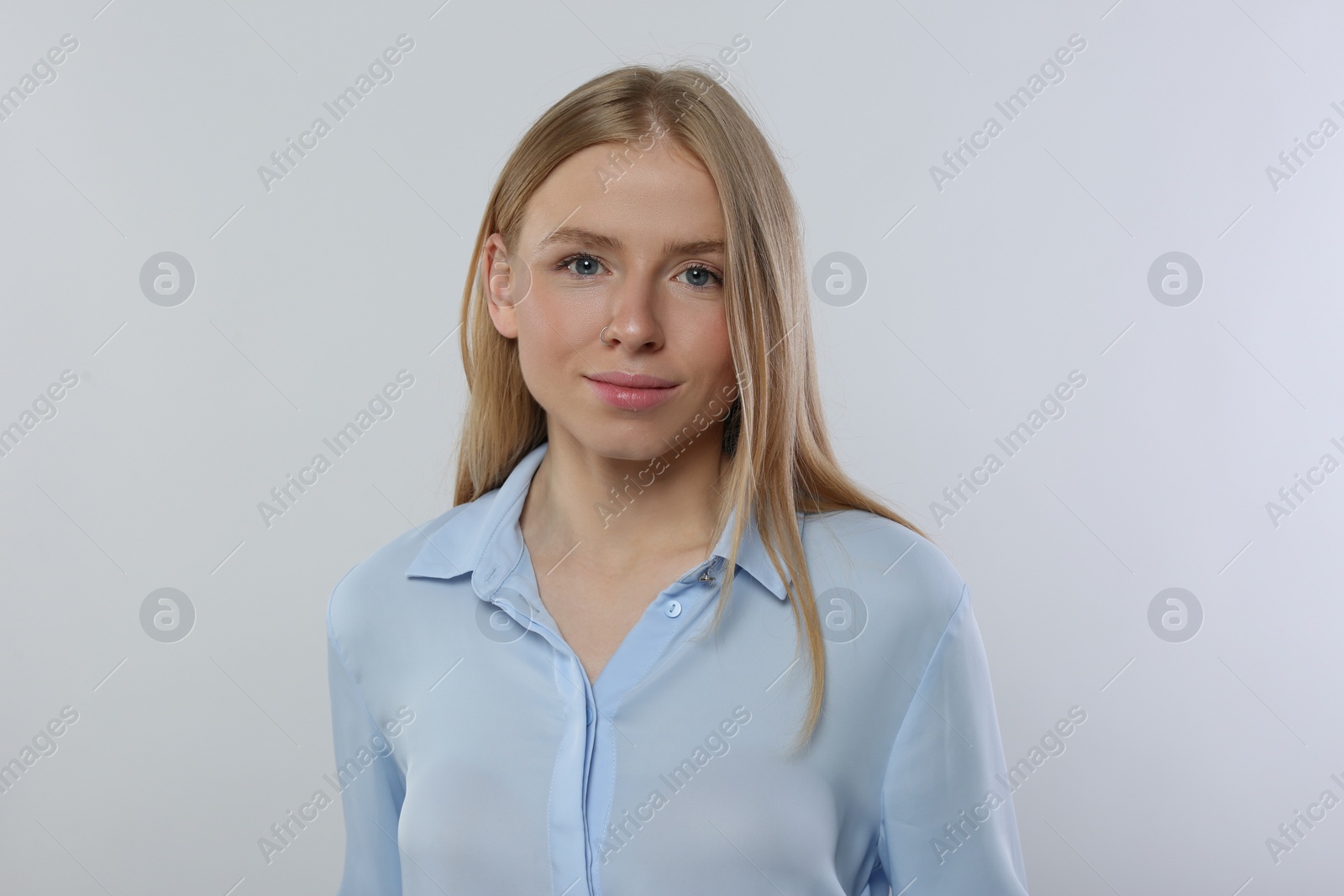 Photo of Portrait of beautiful young woman in stylish blouse on white background