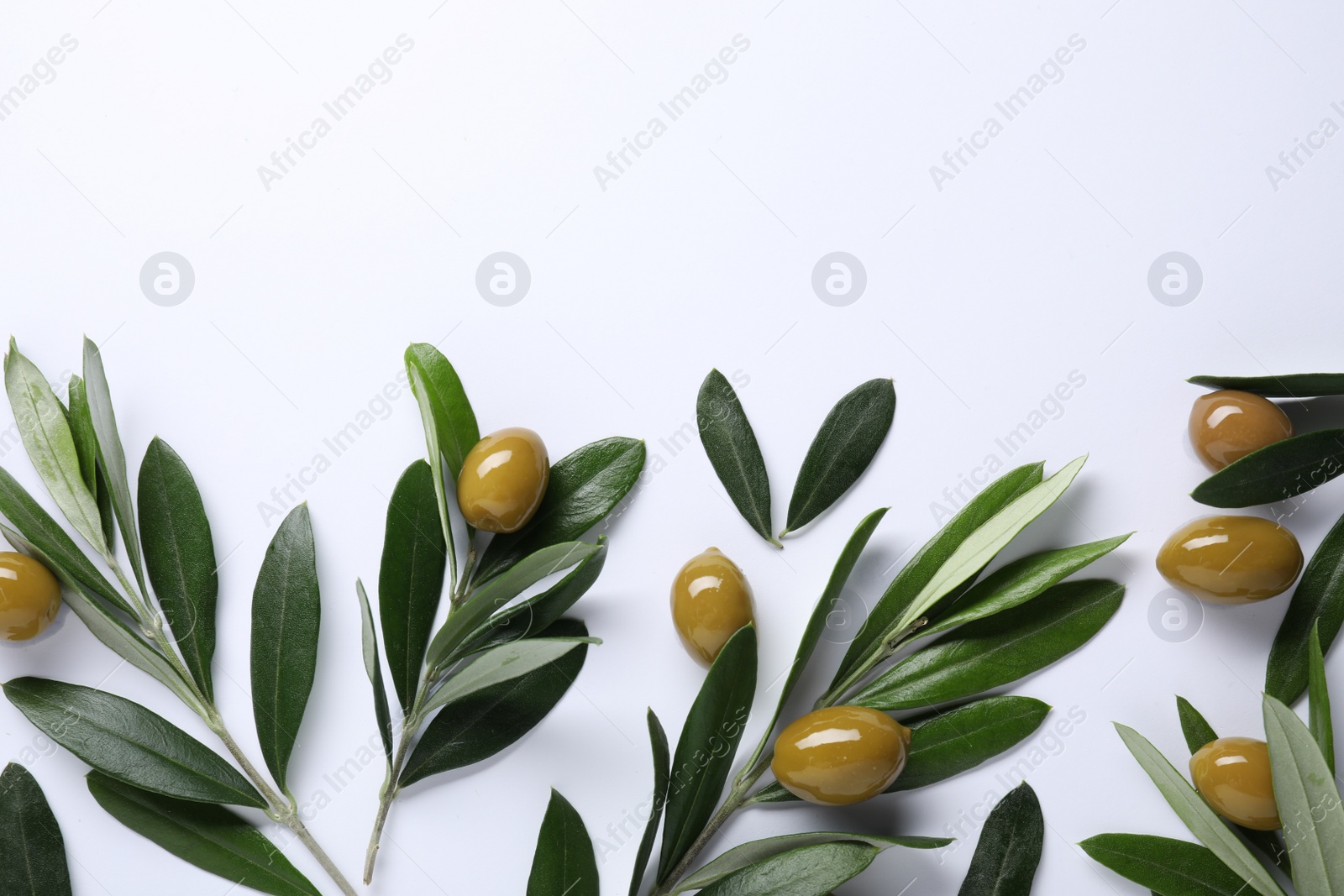 Photo of Fresh green olives and leaves on white background, flat lay. Space for text