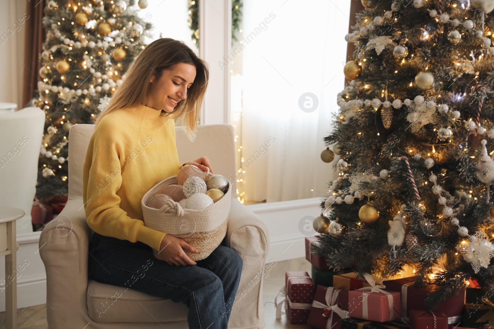 Photo of Beautiful woman decorating Christmas tree at home