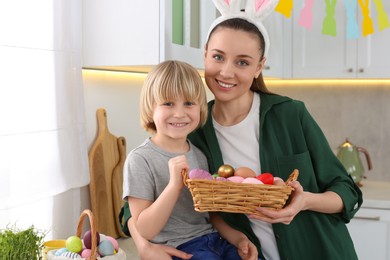 Photo of Mother and her son with Easter eggs in kitchen