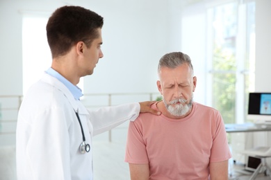 Young urologist comforting upset patient in hospital