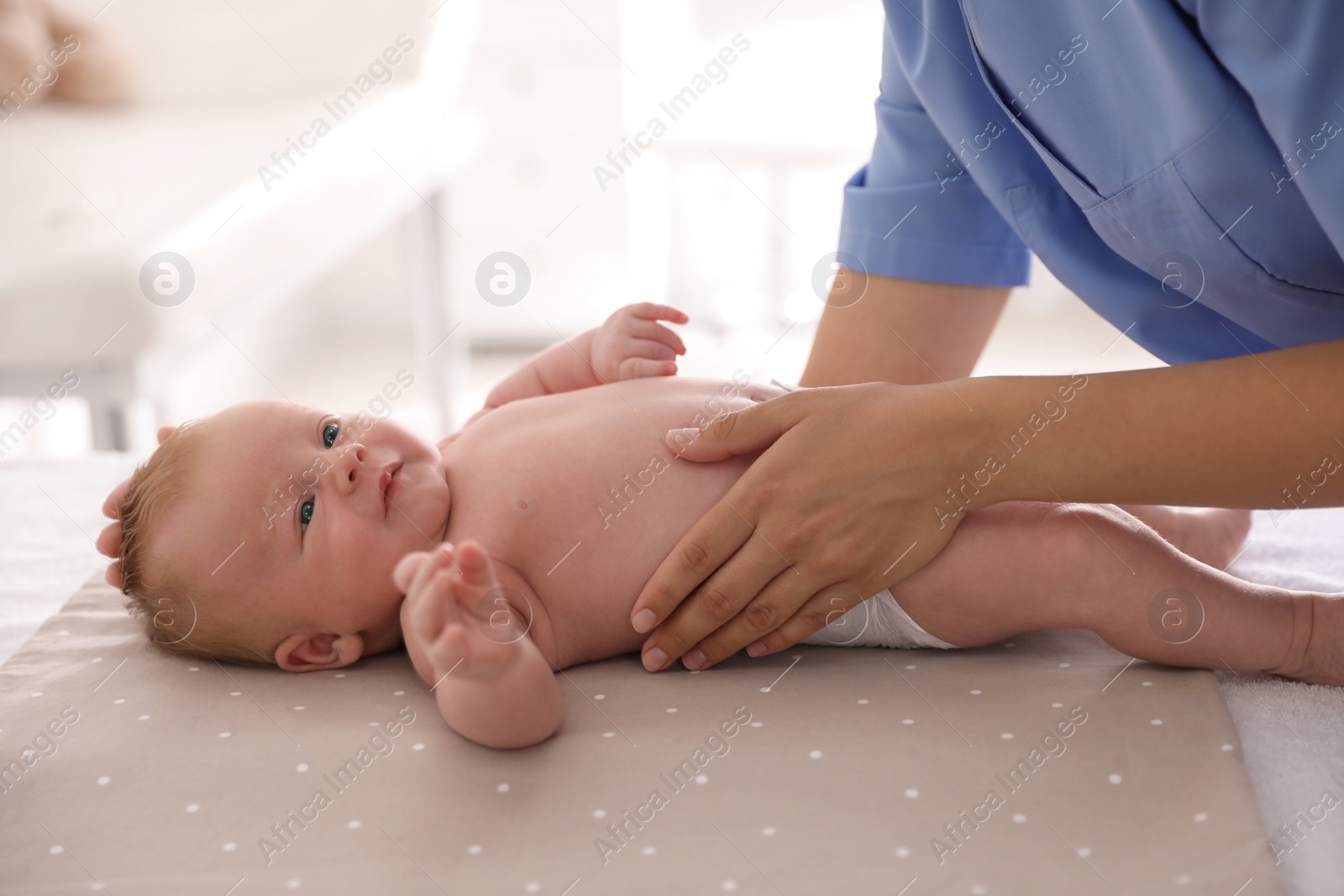 Photo of Doctor examining cute baby in clinic, closeup. Health care