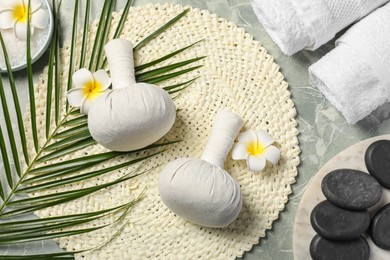 Photo of Spa bags, stones and orchid flowers on light gray marble table, flat lay