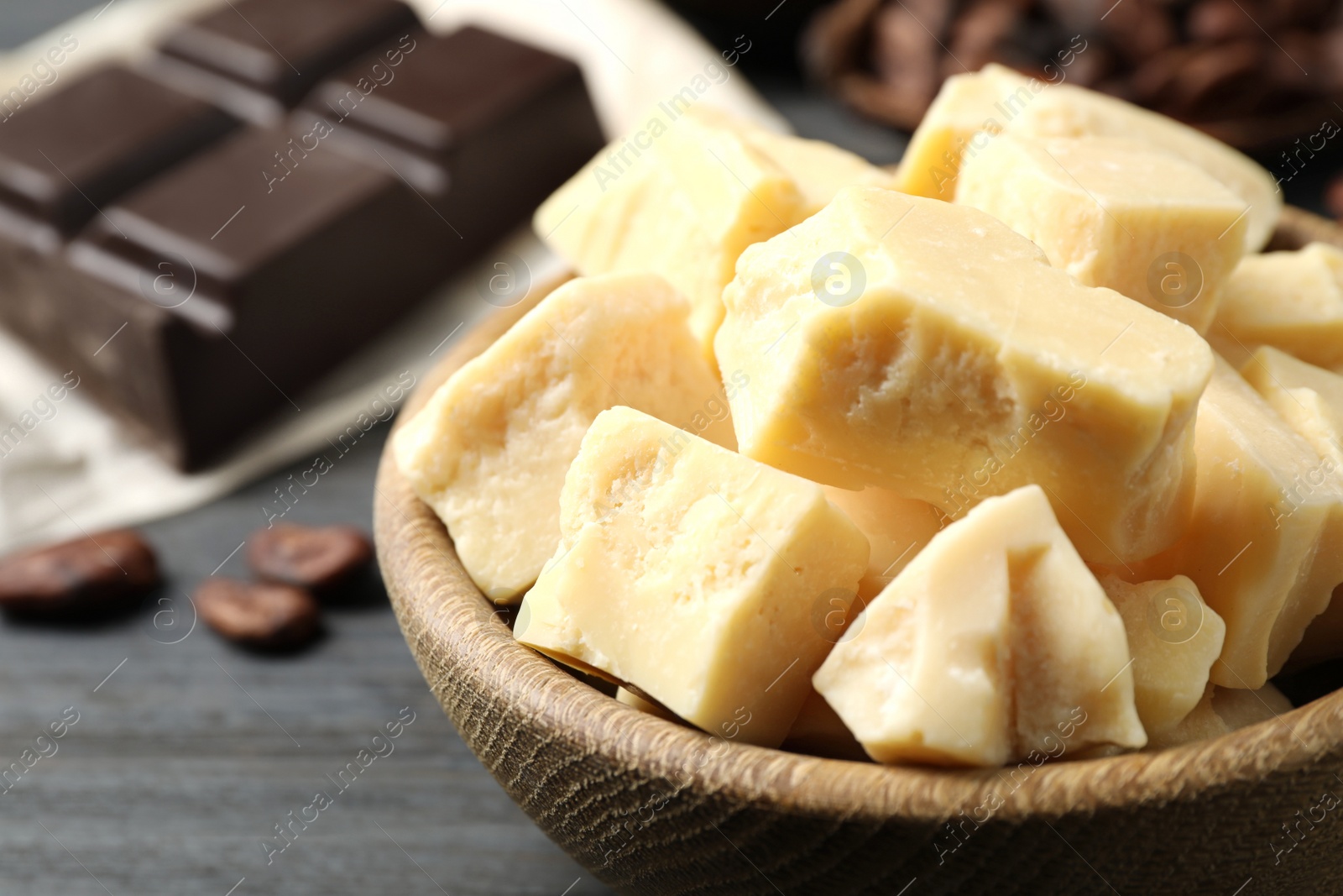 Photo of Organic cocoa butter on black wooden table, closeup