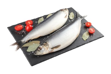 Photo of Slate plate with salted herrings, bay leaves, cherry tomatoes and spices isolated on white