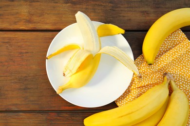 Photo of Many delicious ripe bananas on wooden table, flat lay