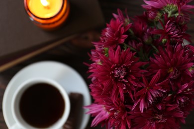 Photo of Composition with beautiful pink chrysanthemum flowers and cup of aromatic tea on wooden table, top view. Space for text