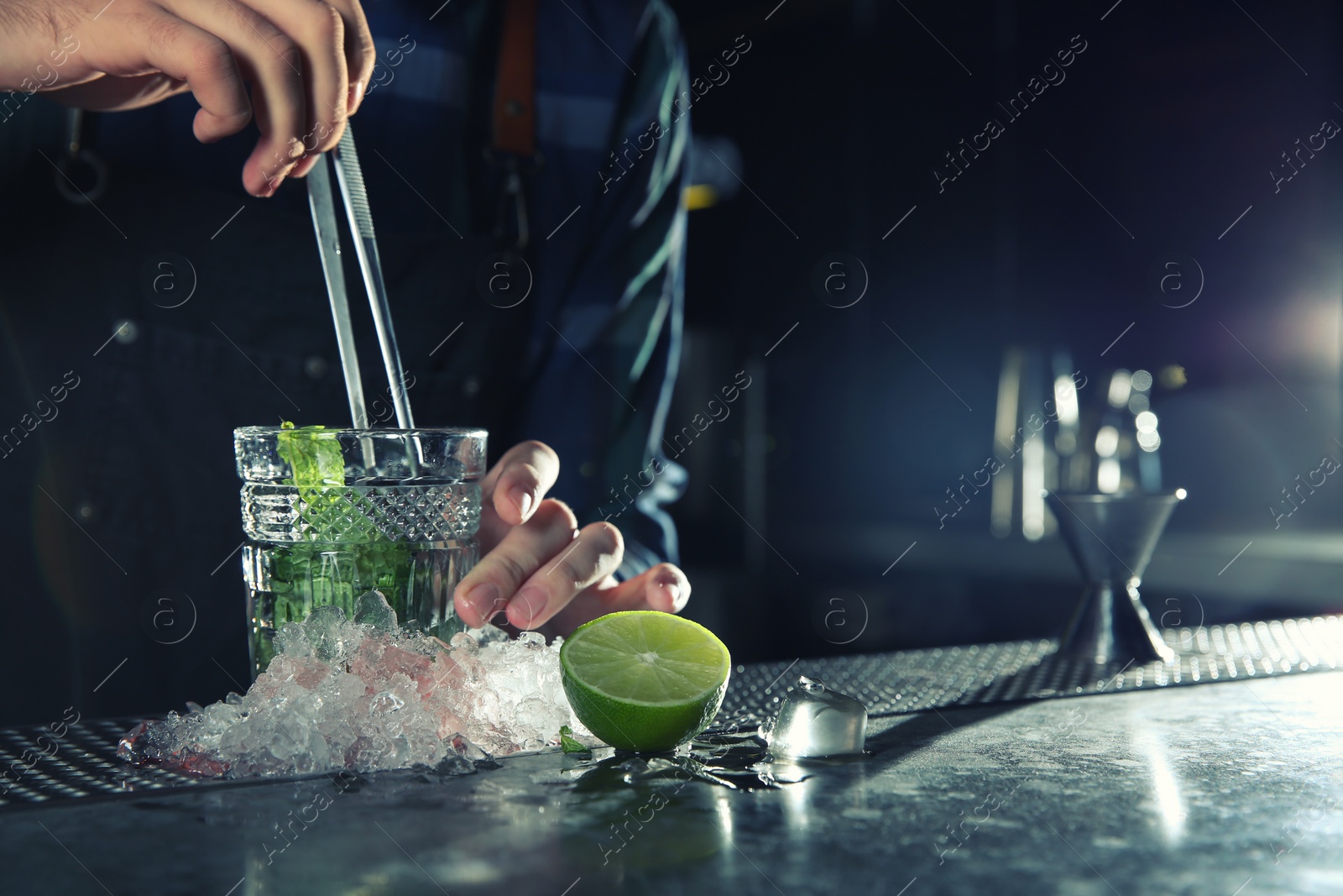 Photo of Barman making Mojito cocktail at counter in pub, closeup. Space for text