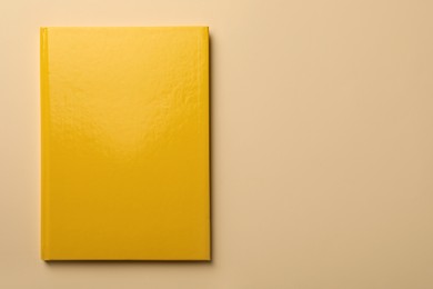 Photo of New yellow planner on beige background, top view. Space for text