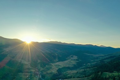 Aerial view of beautiful mountain landscape with village at sunrise