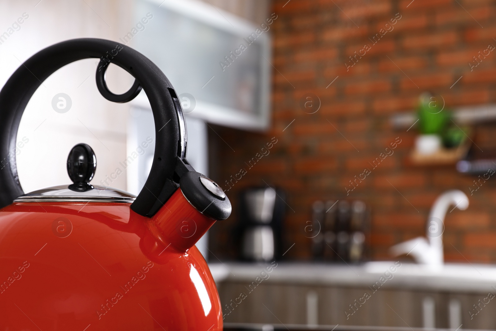 Photo of Modern kettle with whistle in kitchen, closeup. Space for text