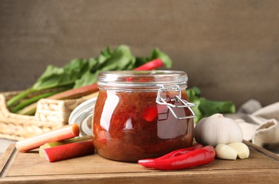 Photo of Tasty rhubarb sauce and ingredients on wooden board