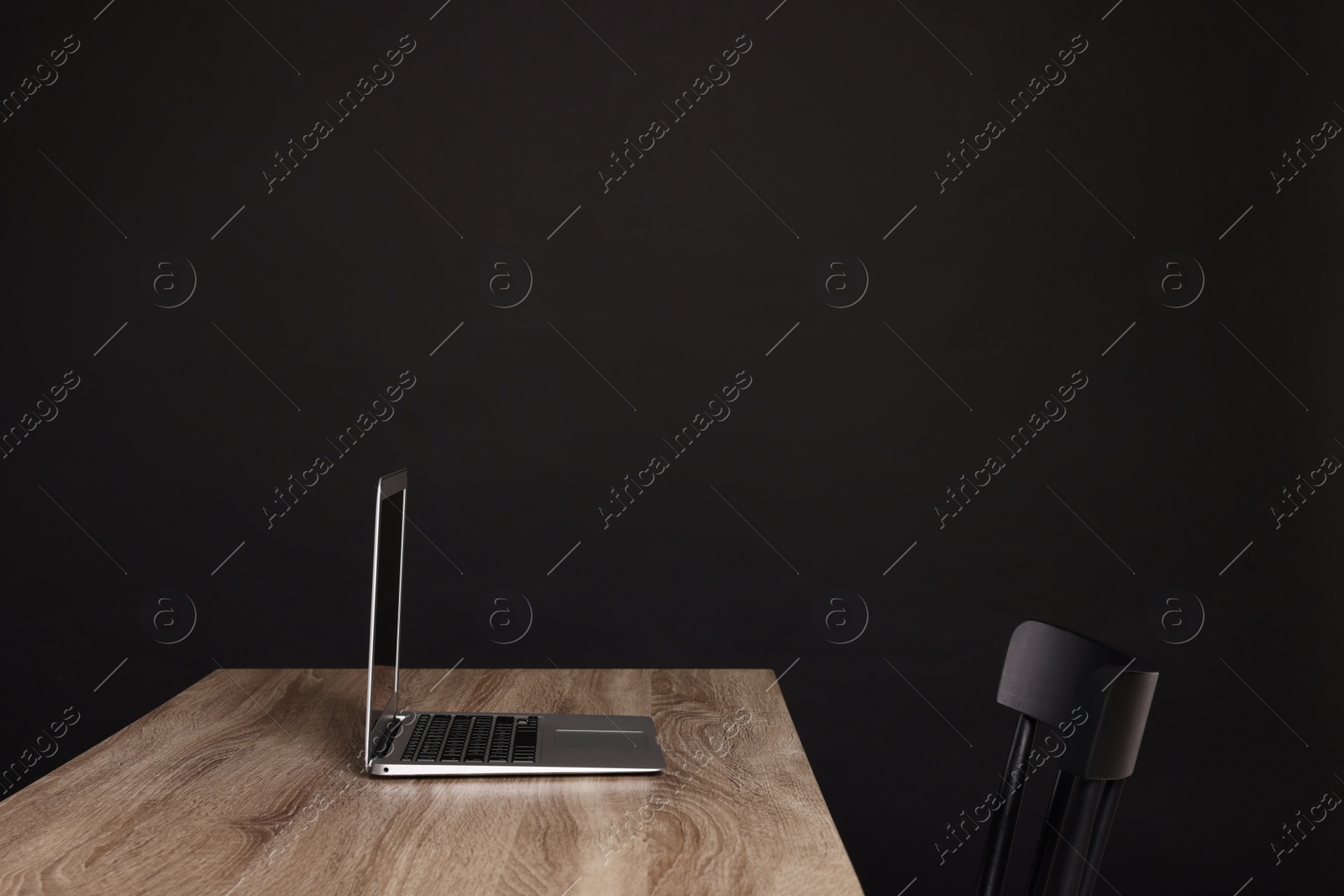 Photo of New modern laptop on empty wooden table indoors, space for text