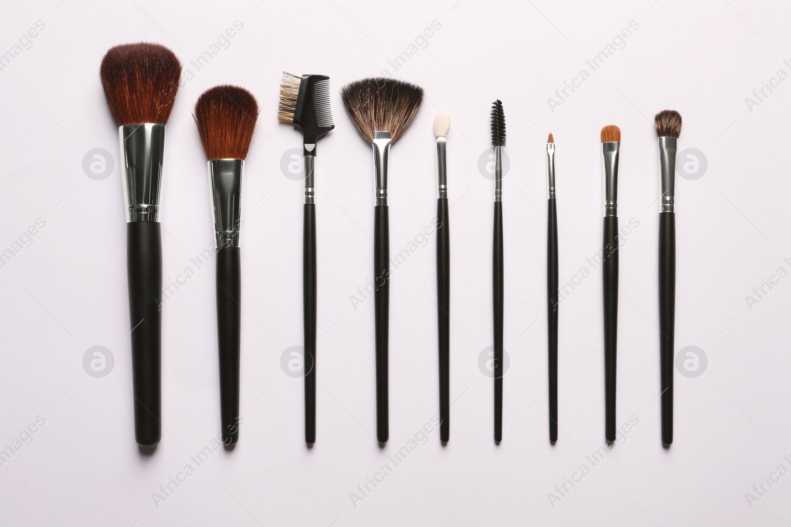 Photo of Different makeup brushes on white background, flat lay