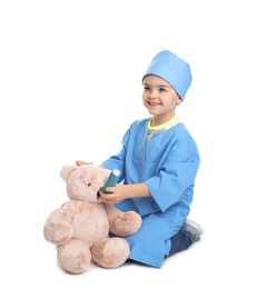 Cute child playing doctor with stuffed toy on white background