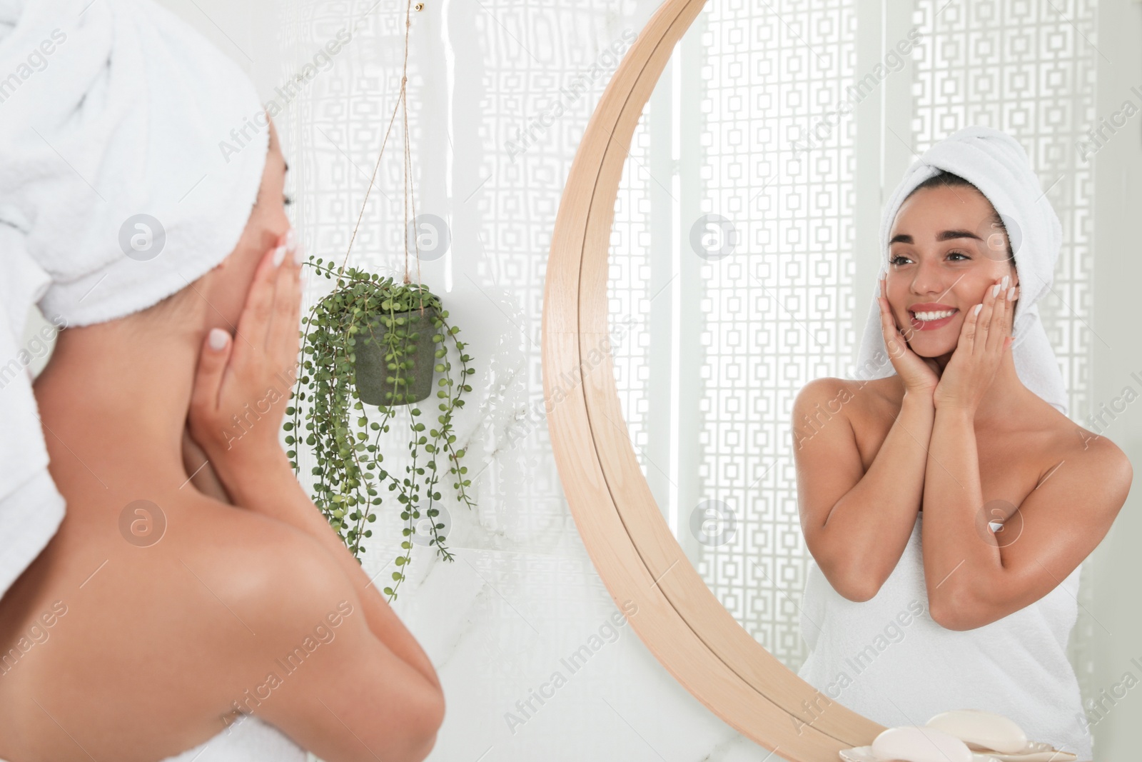 Photo of Beautiful young woman with perfect skin near mirror in bathroom. Facial wash