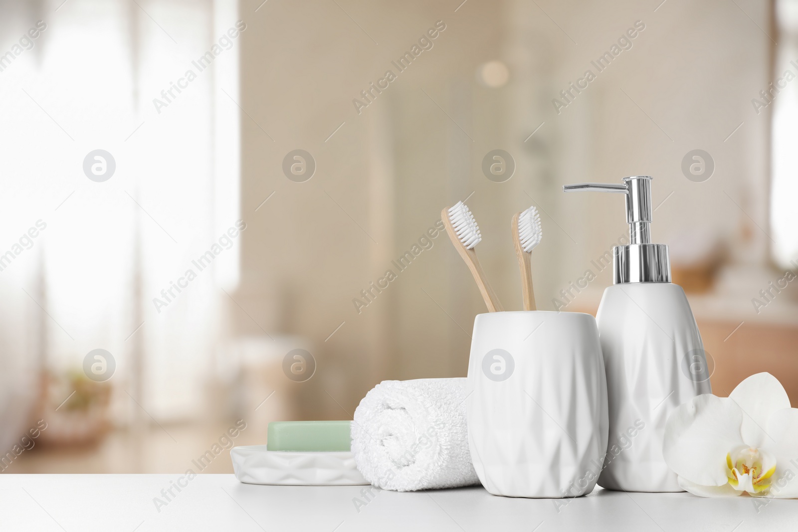 Image of Bath accessories. Different personal care products and flower on white table in bathroom, space for text