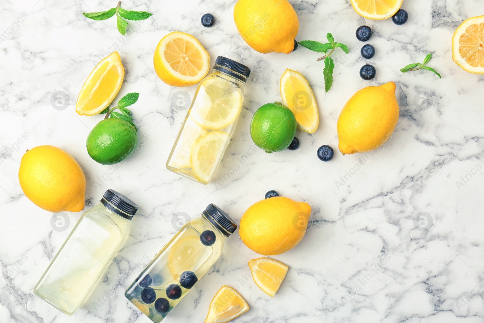 Photo of Flat lay composition with delicious natural lemonade on marble background