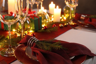 Photo of Christmas place setting with festive decor on table, closeup