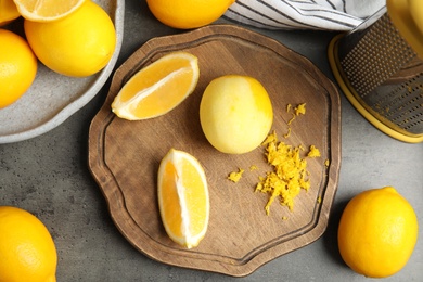 Lemon zest and fresh fruits on grey table, flat lay