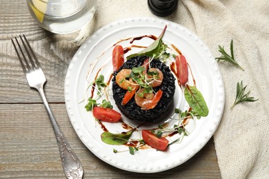 Delicious black risotto with seafood served on wooden table