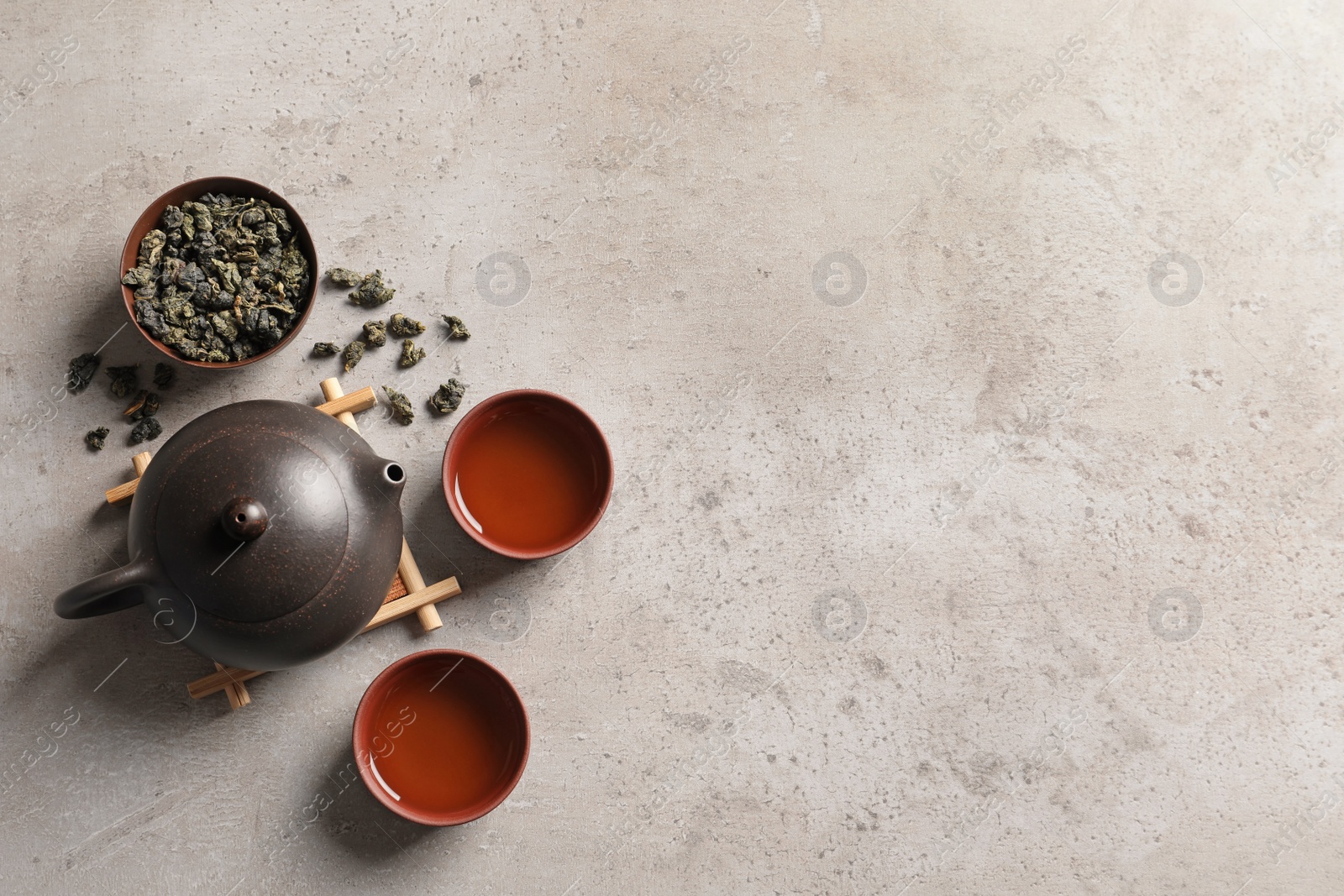 Photo of Flat lay composition with cups of Tie Guan Yin oolong tea and space for text on table