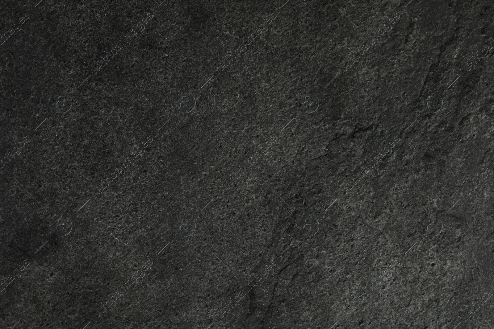 Photo of Texture of dark grey stone surface as background, closeup