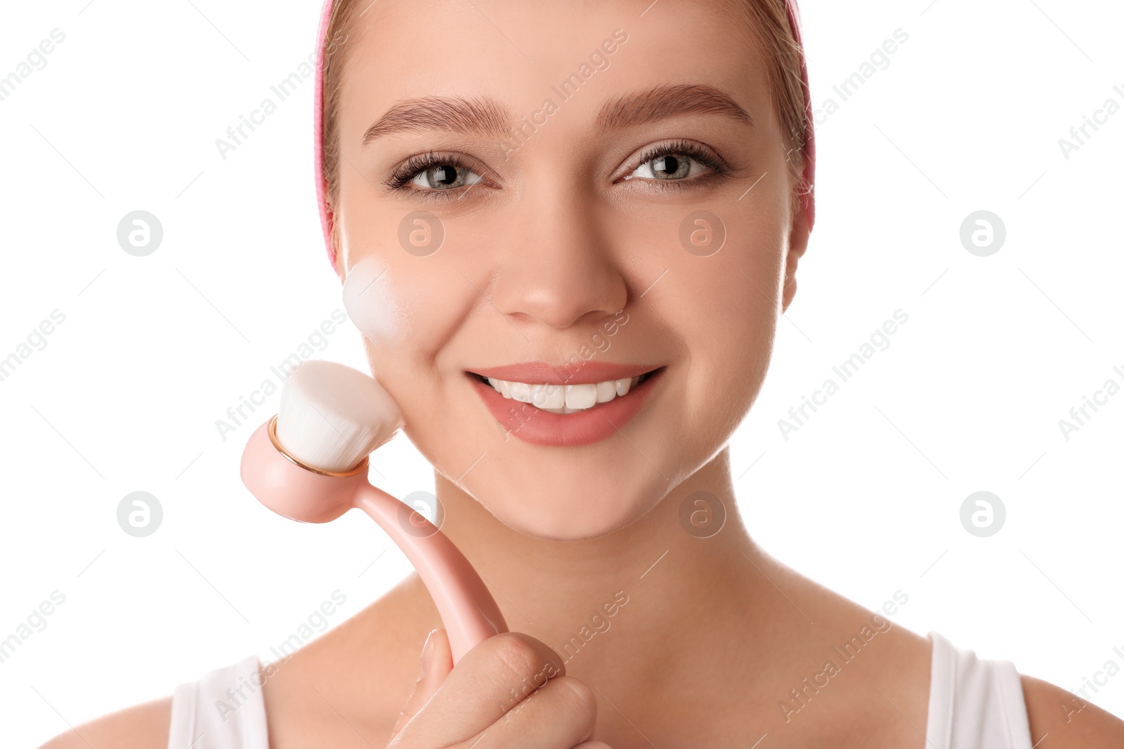 Photo of Young woman washing face with brush and cleansing foam on white background. Cosmetic products