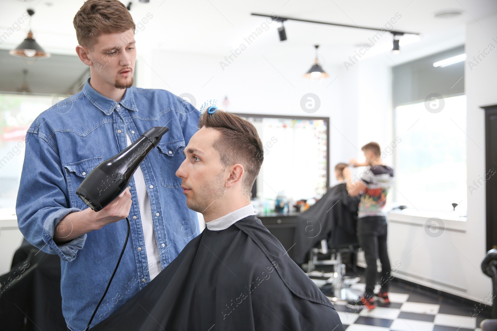 Photo of Professional barber working with client in hairdressing salon. Hipster fashion