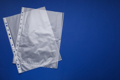 Photo of Punched pockets on blue background, flat lay. Space for text