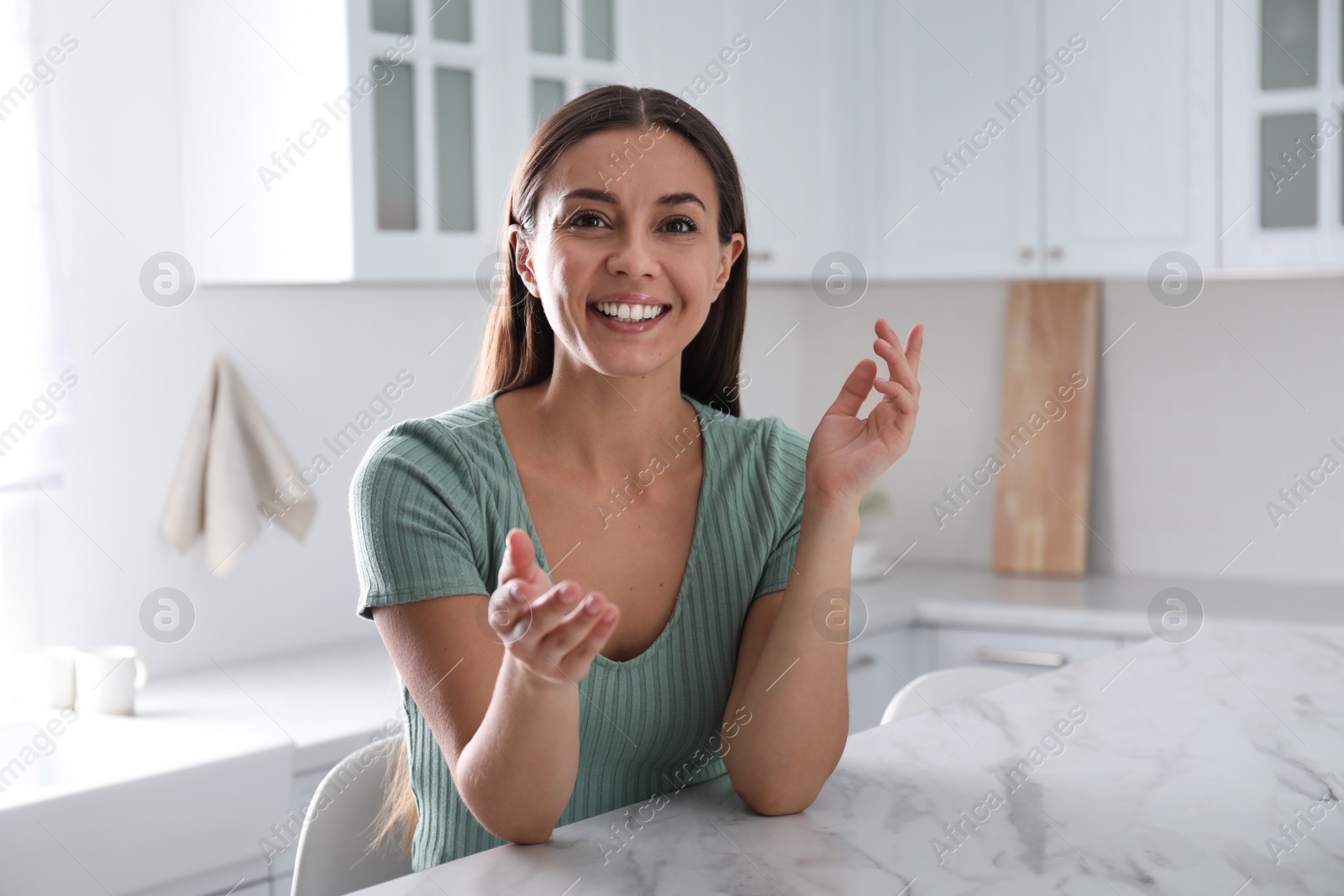 Photo of Young woman talking to his coworkers through video conference indoors, view from webcam