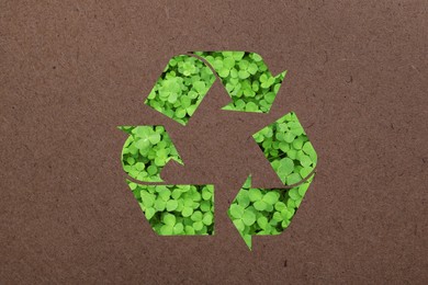 Recycling symbol made of green leaves on kraft paper