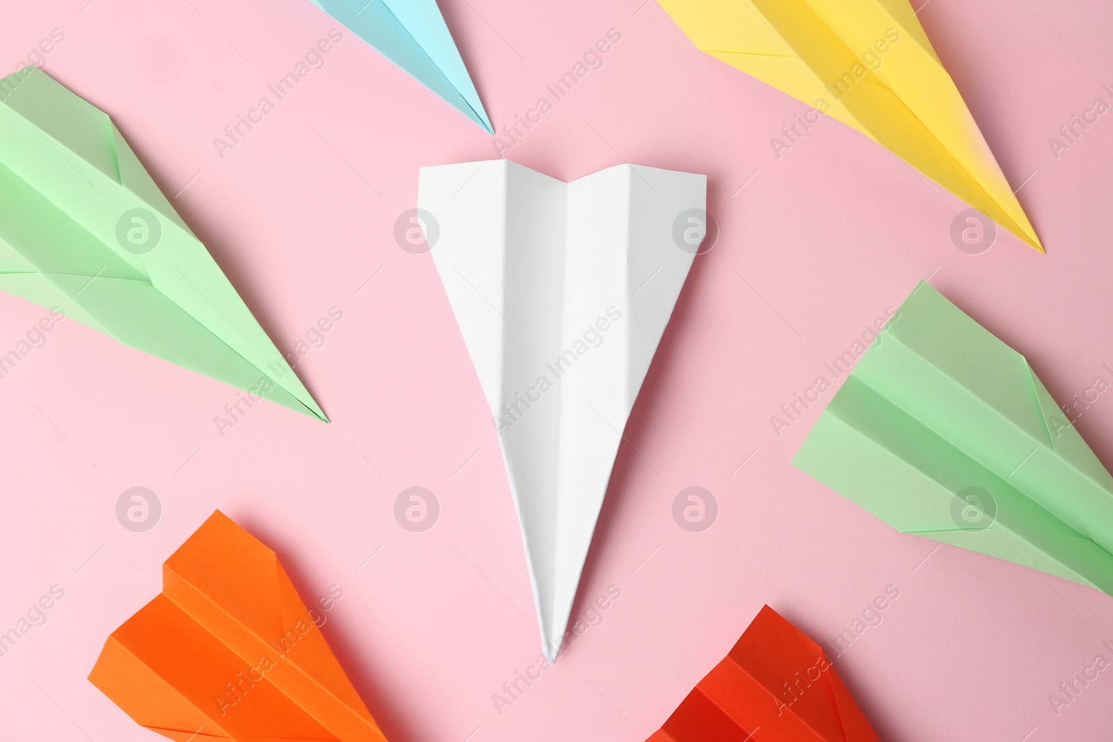 Photo of Colorful paper planes on pink background, flat lay