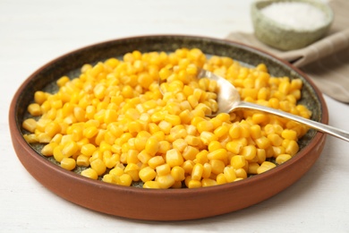 Plate with corn kernels on white table