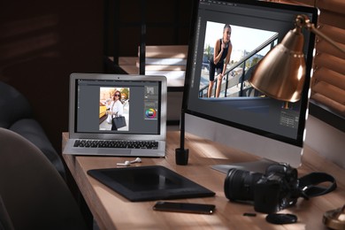 Retoucher's workplace. Computer and laptop with photo editor applications, camera, graphic tablet on table indoors