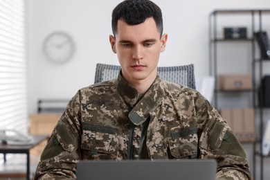 Photo of Military service. Young soldier working in office