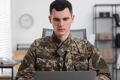 Military service. Young soldier working in office