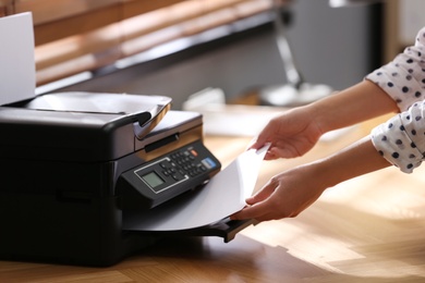 Employee using modern printer in office, closeup