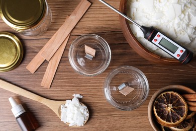 Photo of Flat lay composition with ingredients for homemade candles on wooden background