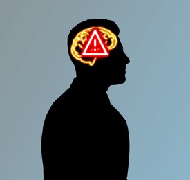 Silhouette of man with illustration of brain and warning sign symbolizing amnesia on grey background